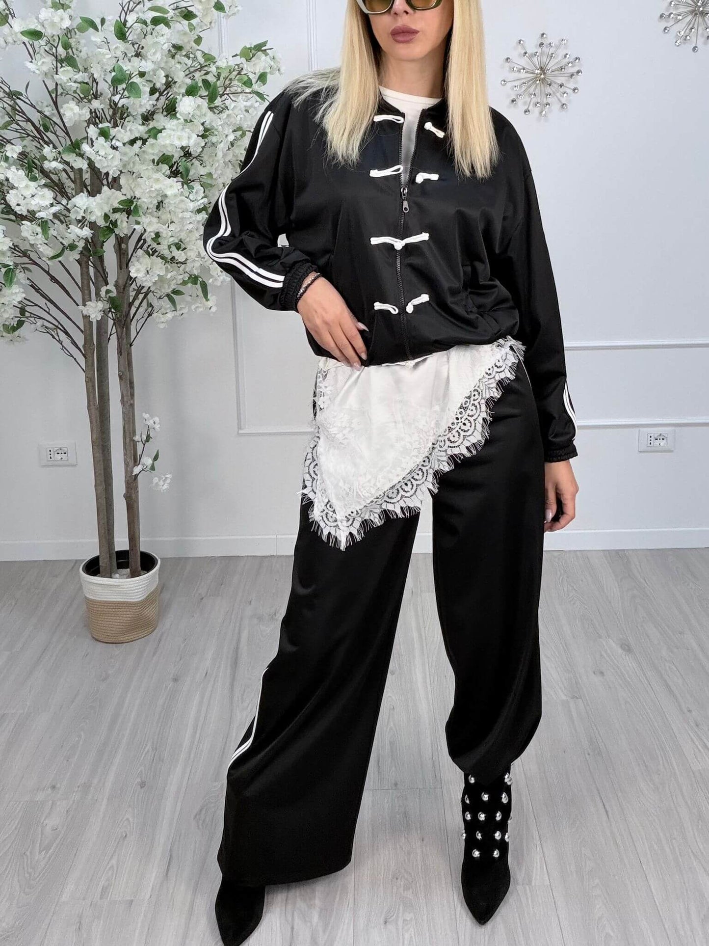 Pantaloni palazzo elastico neri con top abbinato, modello elegante e sportivo, indossati da una donna in piedi.