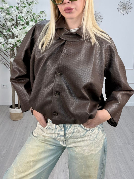 Donna che indossa un bomber ecopelle trama intrecciata Moro, con jeans chiari e occhiali da sole.