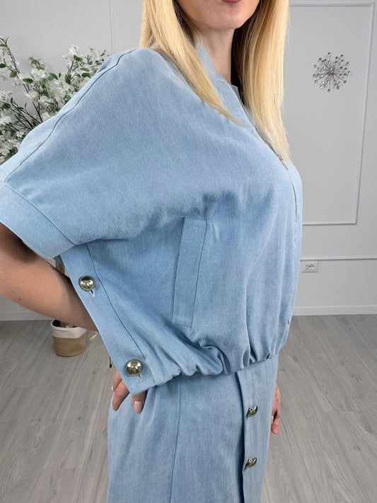 Giacca lyocell denim chiaro con zip, maniche ampie e bottoni laterali, modello moderno, indossata da una donna.